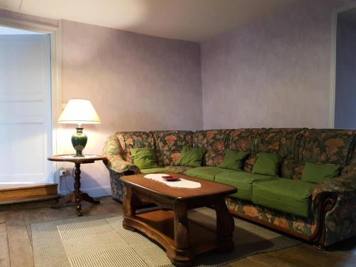 a living room with a green couch and a table at Gîte de France à Chasteaux 2 épis - Gîte de France 4 personnes MAE-9364 in Chasteaux