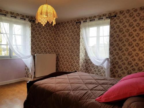 a bedroom with a bed and two windows and a chandelier at Gîte de France à Chasteaux 2 épis - Gîte de France 4 personnes 364 in Chasteaux