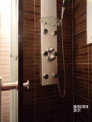 une douche dans une salle de bain avec une pomme de douche dans l'établissement Gîte de France Gite de la tuilerie 3 épis - Gîte de France 3 personnes MAE-9394, à Arnac-Pompadour