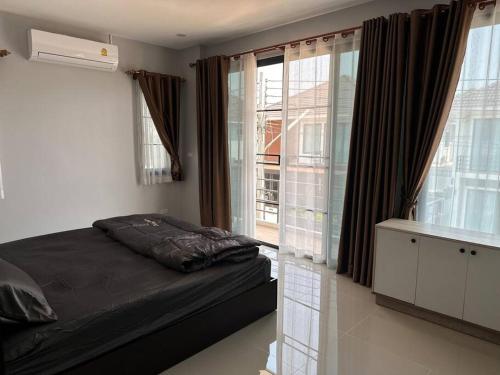 a bedroom with a bed and a large window at issara2 in Udon Thani