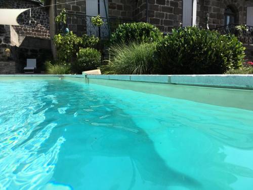 une piscine avec de l'eau bleue dans une cour dans l'établissement Gîte de France Gîte la chapelle avec piscine 3 épis - Gîte de France 6 personnes MAE-9464, à Saint-Solve