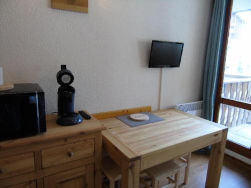 Cette chambre dispose d'une table, d'une télévision et d'une table en bois. dans l'établissement Résidence Thabor - Studio pour 3 Personnes MAE-5704, à Modane