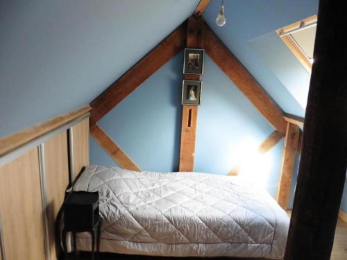 Un dormitorio con una cama en un ático en Gîte de France Gîte la chapelle avec piscine 3 épis - Gîte de France 6 personnes MAE-9464, en Saint-Solve