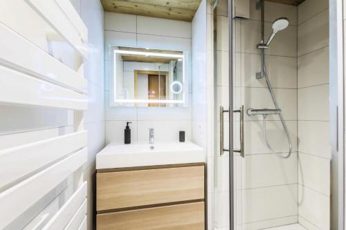 uma casa de banho com um lavatório e um chuveiro em Quartier Crève Cœur - maeva Home - Appartement 2 pièces 6 personnes skis a 76 em Valmorel