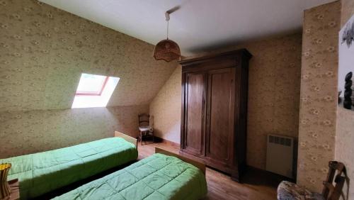 una camera con due letti verdi e una finestra di Gîte de France à Latronche 2 épis - Gîte de France 6 personnes 454 