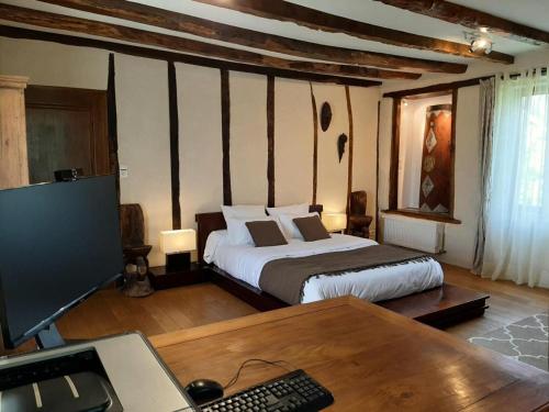 a bedroom with a bed and a desk with a computer at Gîte de France Gîte des papous 4 épis - Gîte de France 10 personnes MAE-9494 in Pierrefitte