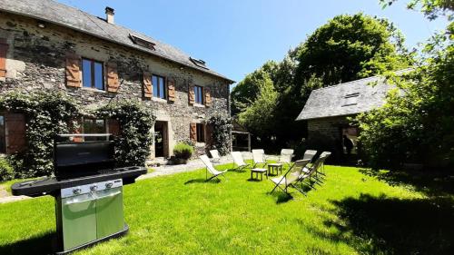 a garden with chairs and a stove in front of a building at Gîte de France Gîte des papous 4 épis - Gîte de France 10 personnes MAE-9494 in Pierrefitte
