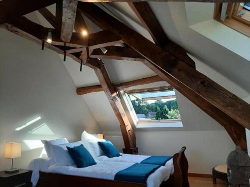 ein Schlafzimmer mit einem Bett im Dachgeschoss in der Unterkunft Gîte de France Gîte des papous épis - Gîte de France 494 in Pierrefitte