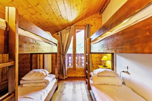 - une chambre avec 2 lits dans une maison en bois dans l'établissement Résidence Les Fermes de Méribel - maeva Home - Appartement 5 pièces 10 personnes Prestige MAE-1374, à Les Allues