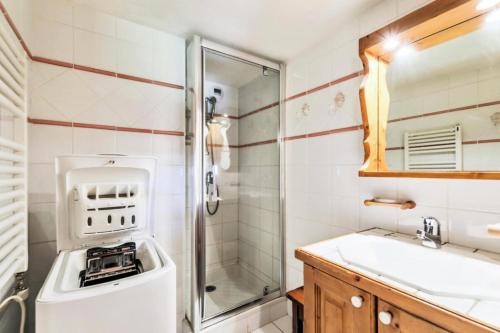 a bathroom with a sink and a washing machine at Résidence Les Fermes de Méribel - maeva Home - Appartement pièces Prestige 74 in Les Allues