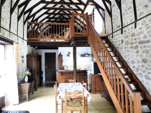 une salle à manger avec un escalier en bois et une table dans l'établissement Gîte de France Gîte de la xaintrie 2 épis - Gîte de France 4 personnes MAE-9534, à Servières-le-Château