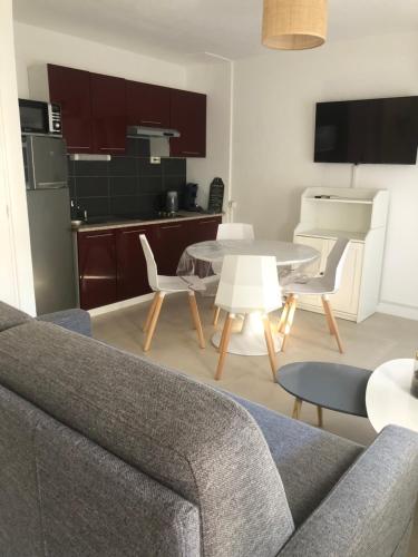 un salon avec un canapé et une table dans l'établissement Agréable appartement Chez Mamé Jeanne au Grau du Roi, au Grau-du-Roi