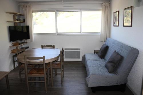 ラ・モンジーにあるAppartement à la Mongie avec accès direct aux pistes - Appartement 3 Pièces 6 personnes MAE-1230のテーブルと青いソファのあるリビングルーム