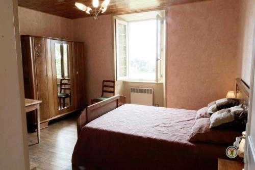 Gîte de France Laclefdeschamps 3 épis - Gîte de France 10 personnes MAE-9514 في Luc: غرفة نوم بسرير ونافذة وكرسيين