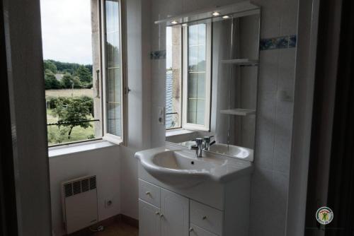 Gîte de France Laclefdeschamps 3 épis - Gîte de France 10 personnes MAE-9514 في Luc: حمام أبيض مع حوض ونوافذ