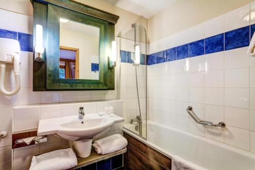 une salle de bain avec un lavabo, un miroir et une baignoire dans l'établissement Résidence Les Arcs 1950 Le Village - maeva Home - Appartement 3 pièces 6 personnes Selection MAE-1630, à Bourg-Saint-Maurice
