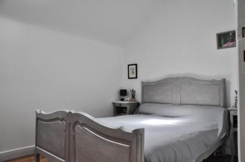- une chambre avec un lit blanc et un cadre en bois dans l'établissement Gîte de France à Soudeilles épis - Gîte de France 574, 