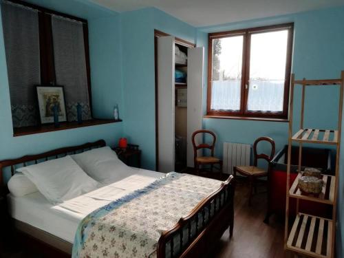 une chambre avec un lit dans une pièce bleue dans l'établissement Gîte de France Gîte communal 2 épis - Gîte de France 3 personnes MAE-9604, à Saint-Hilaire-les-Courbes