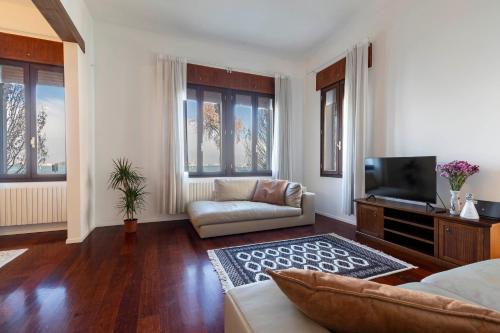 a living room with a couch and a tv at Palazzo Boito Luxury Apartment on Lido with Venice view in Venice-Lido