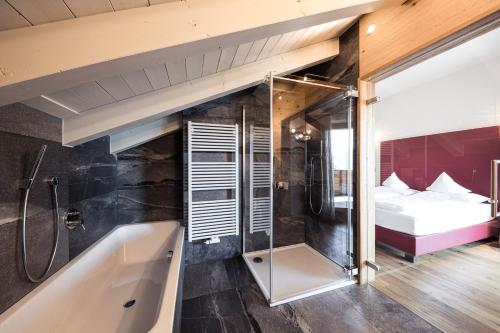 シェーナにあるTorgglerhofのバスルーム(バスタブ付)、ベッド1台が備わります。