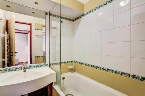 une salle de bain avec une baignoire, un lavabo et un miroir dans l'établissement Résidence La Marelle et Le Rami - maeva Home - Appartement 2 pièces 5 personnes Selection MAE-2243, à La Plagne Tarentaise