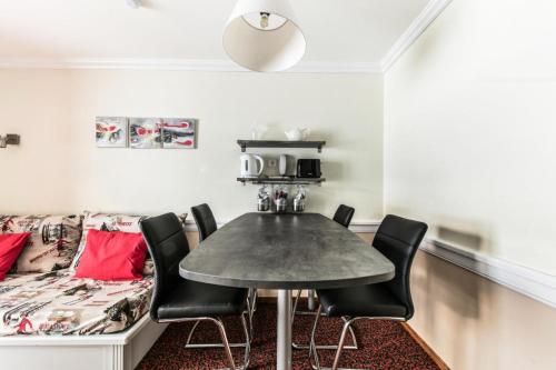 une salle à manger avec une table, des chaises et un canapé dans l'établissement Résidence Le Mont Soleil - maeva Home - Appartement 2 pièces 4 personnes Confort MAE-2057, à Mâcot La Plagne