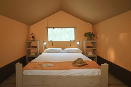 a bedroom with a bed with a hat on it at Delfino Tuscany Resort in Marina di Cecina