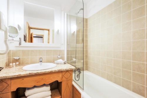 une salle de bain avec un lavabo, une douche et une baignoire dans l'établissement Résidence Les Arcs 1950 Le Village - maeva Home - Appartement 2 pièces 4 personnes Exclusive MAE-2311, à Bourg-Saint-Maurice