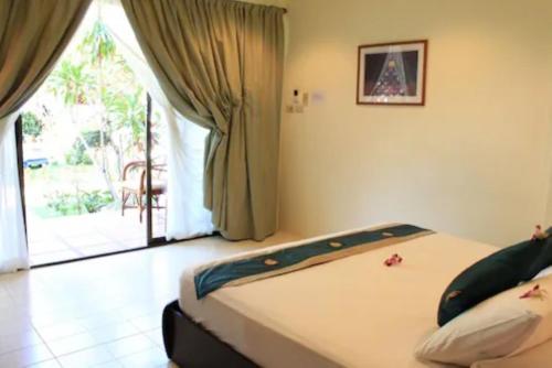 a bedroom with a bed and a door to a patio at The Waterfront Hotel at Fishermans Village in Bophut 