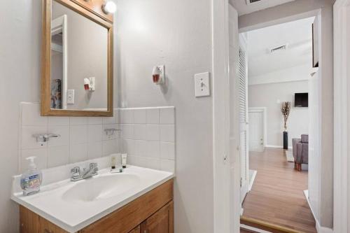La salle de bains blanche est pourvue d'un lavabo et d'un miroir. dans l'établissement Vibrant Stylish & Perfectly Located In Bella Vista, à Philadelphie