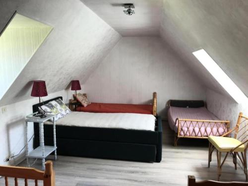 a attic bedroom with a bed and a table at Gîte de France Le rouzeyrol 3 épis - Gîte de France 12 personnes MAE-9674 in Charbonniers