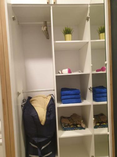 einen begehbaren Kleiderschrank mit weißen Regalen und blauen Handtüchern in der Unterkunft Homestay 2 Bedroom KLCC Wifi Netflix in Kuala Lumpur