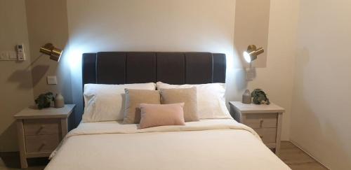 een bed met een zwart hoofdeinde en witte kussens bij Homestay 2 Bedroom KLCC Wifi Netflix in Kuala Lumpur