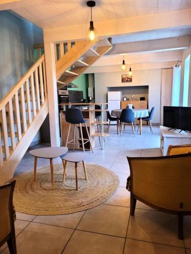un salon avec des chaises, des tables et un escalier dans l'établissement Gîte de France La maison de thienot 3 épis - Gîte de France 3 personnes MAE-9724, à La Bitarelle
