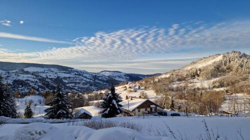 una montagna innevata con una casa e alberi di Les yeux du lac a Gérardmer