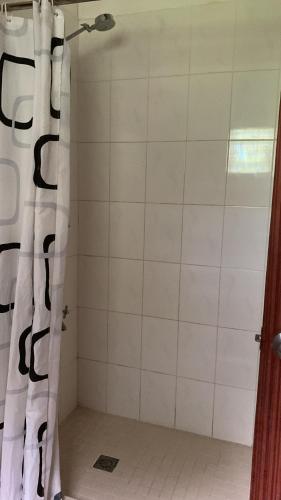 荷尼阿拉的住宿－Canopy cottage，配有黑色和白色淋浴帘的淋浴