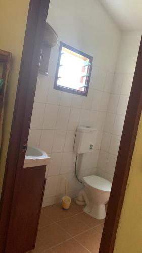 a bathroom with a toilet and a window at Canopy cottage in Honiara