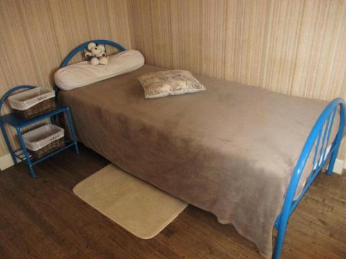 a bed with a teddy bear sitting on top of it at Gîte de France à Sioniac 2 épis - Gîte de France 5 personnes MAE-9744 in Sioniac