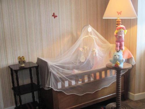 a baby crib with a canopy and two stuffed animals at Gîte de France à Sioniac 2 épis - Gîte de France 5 personnes MAE-9744 in Sioniac