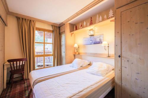 une chambre d'hôtel avec un lit et une fenêtre dans l'établissement Résidence Les Arcs 1950 Le Village - maeva Home - Appartement 2 pièces 4 personnes Sélection MAE-3657, à Bourg-Saint-Maurice