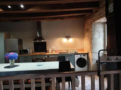 uma cozinha com um fogão e uma máquina de lavar roupa em Gîte de France Des alpagas 3 épis - Gîte de France 6 personnes 784 em Chaumeil