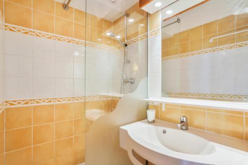 ein Bad mit einem Waschbecken und einem Spiegel in der Unterkunft Résidence Les Horizons d'Huez - maeva Home - Appartement 2 pièces 4 personn 59 in Huez