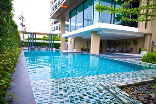 a swimming pool in front of a building at Baan Im Em by little dragon in Hua Hin