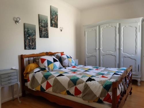 une chambre avec un lit avec une couette colorée dans l'établissement Gîte de France à Brive-la-Gaillarde 3 épis - Gîte de France 4 personnes MAE-9794, à Brive-la-Gaillarde