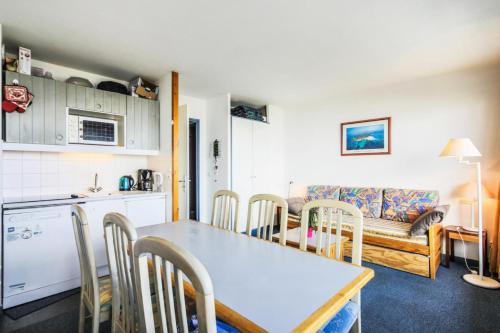 une cuisine et un salon avec une table et des chaises dans l'établissement Résidences quartier Charmettoger - maeva Home - Appartement 3 pièces 6 personnes - Budget MAE-4507, à Arc 1800