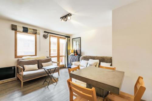 un salon avec un canapé et une table dans l'établissement Résidence Les Ravines - maeva Home - 2 pièces 4 personnes Sélection MAE-3913, à Les Allues