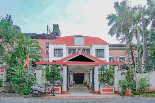 una casa con tetto rosso e una moto parcheggiata di fronte di Collection O Sukhsagar Resort a Lonavala