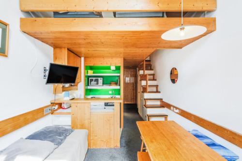 Cette petite maison comprend un lit et un bureau. dans l'établissement Résidences quartier Charmettoger - maeva Home - Grand studio duplex 5 personnes Budget MAE-4995, à Arc 1800