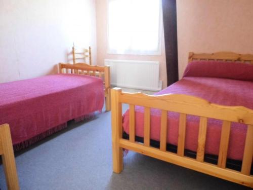 um quarto com 2 camas e lençóis roxos em Gîte de France Le moulin 2 épis - Gîte de France 4 personnes 844 em Argentat