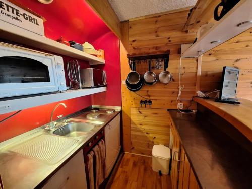 une petite cuisine avec un évier et un micro-ondes dans l'établissement Résidence Tournavelles - Appartement 2 pièces 5 personnes au pied des pistes et des commerces, proche de l'ESF et de la garderie dans le village des Vill MAE-1739, à Arc 1800